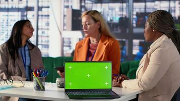 Multicultural team of specialists using mockup copy space in the office, working with resilience to accomplish enterprise objectives. Manager and employees meeting for a briefing. Camera A. video
