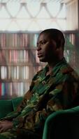 Vertical African american military trooper sharing flashbacks from the war during counseling session, tying to cure PTSD and shell shock. Army veteran deals with depression after traumatic scenes. Camera B. video