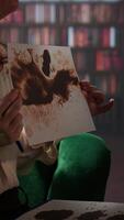 Vertical Armed forces veteran in uniform sits with a therapist during counseling, viewing a Rorschach test illustration to share feelings and discuss trauma. PTSD and shell shock syndrome. Camera A. video