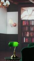 Vertical Empty therapy room with stylish green armchairs and vintage warm decor, inviting space with bookshelves. Perfect for psychotherapy, counseling sessions or consultations in a cozy setting. video