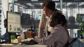 Female employee and manager gathered around a workstation discussing objectives and strategizing solutions to solve administrative tasks faster. Aligning business goals and milestones. Camera A. video