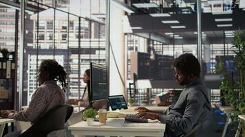 African american specialist on a landline phone call negotiating funds at his desk, managing an expansion project and discussing growth strategies. CEO multitasking for a career success. Camera B. video
