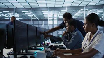 Manager supervising server room workers developing disaster recovery plans ensuring minimal downtime. Supervisor oversees data center technicians using data analytics to monitor performance, camera A video