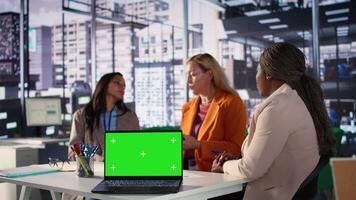 Multicultural team of specialists using mockup copy space in the office, working with resilience to accomplish enterprise objectives. Manager and employees meeting for a briefing. Camera B. video