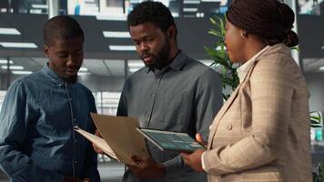 professionell team analyserar arkiveras data på en finansiell fil under möte, samarbetande på företag lösningar och lösning uppgifter till förbättra prestanda för lång termin tillväxt. kamera a. video