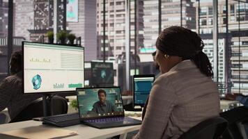 Black director discuss on a call with business consultant for a new strategy, uses remote communication on online conference to establish objectives. Connection with specialist. Camera B. video