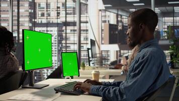 Black businessman analyzing financial data next to chroma key screen, reviewing company strategies on pc and contributing to business development and decision making. Successful forecast. Camera B. video