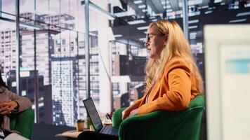 Determined businesswoman speaking on a phone call to ensure project development success, multitasking in a corporate office. Female CEO using remote connection on her smartphone. Camera B. video
