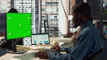 Male executive seated at his workstation with isolated copy space multitasking, analyzing financial reports to support strategic business goals and decision making processes. Camera A. video