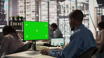 Male executive seated at his workstation with isolated copy space multitasking, analyzing financial reports to support strategic business goals and decision making processes. Camera B. video