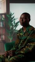 Vertical African american war veteran being dissociative and suffers from depersonalization, trying to cure shell shock after bloody combat scenes. Army soldiers experiences derealization condition. Camera B. video