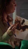 Vertical Military veteran studies Rorschach inkblot in therapy session with counselor, addressing PTSD and trauma recovery problems. Woman shows psychological support for mental health care. Camera B. video