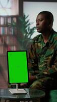 Vertical Infantry serviceman attending a therapy session with psychologist next to mockup display, suffering from PTSD after combat. Female counselor offers help and support to army officer. Camera A. video