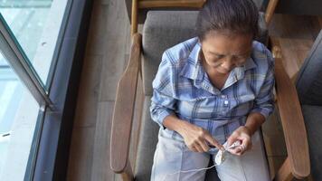 Close up of elderly hands skillfully crocheting a blue piece, capturing the delicate details of needlework and the dedication to the art of creating handmade crafts. video