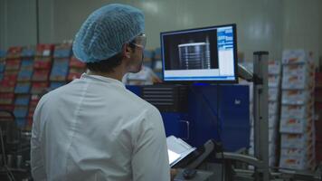 The production control supervisor inspects and controls the operation of machines in the manufacturing line of a canned fish industry video