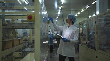 The production control supervisor inspects and controls the operation of machines in the manufacturing line of a canned fish industry video