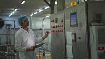 The production control supervisor inspects and controls the operation of machines in the manufacturing line of a canned fish industry video