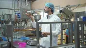 Production control supervisor inspects and controls the operation of each step in the production line of a canned fish factory video