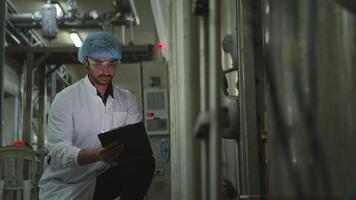 The production control supervisor inspects and controls the operation of machines in the manufacturing line of a canned fish industry video