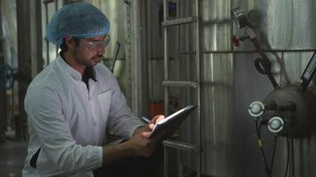 The production control supervisor inspects and controls the operation of machines in the manufacturing line of a canned fish industry video