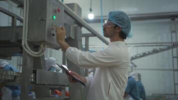 The production control supervisor inspects and controls the operation of machines in the manufacturing line of a canned fish industry video