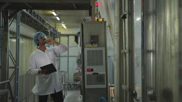 The production control supervisor inspects and controls the operation of machines in the manufacturing line of a canned fish industry video