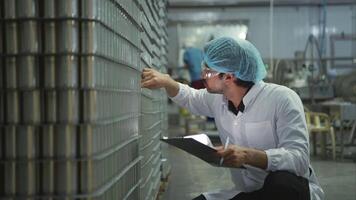 Production control supervisor inspects and controls the operation of each step in the production line of a canned fish factory video