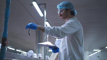 Raw material quality inspectors evaluate and inspect fish pieces before they enter the canned fish production process video