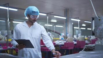 produktion kontrollera handledare inspekterar och kontroller de drift av varje steg i de produktion linje av en konserverad fisk fabrik video