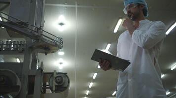 Production control supervisor inspects and controls the operation of each step in the production line of a canned fish factory video