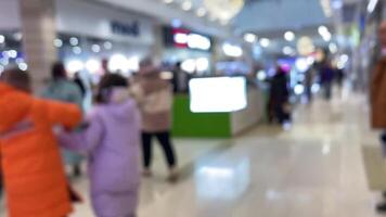 The bustling mall is filled with a vibrant winter crowd, diverse individuals, and busy stores, creating a captivating atmosphere of community and excitement during the holiday season video