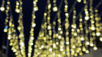 A stunning display of glowing golden fairy lights creates a magical atmosphere for festive occasions, enhancing the night with captivating bokeh effects that draw everyone in video