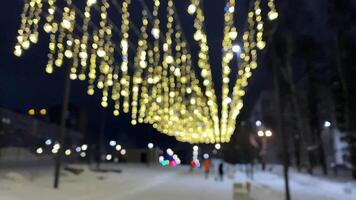 Envision a magical winter scene with a cozy walkway, aglow with warm yellow lights, amidst a snowy backdrop under a starlit sky, creating an enchanting and captivating effect video