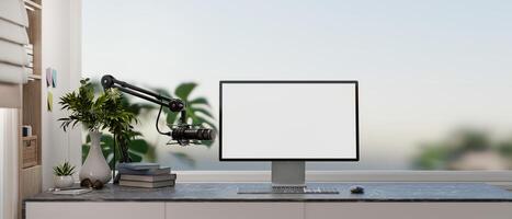 A modern, simple office workspace featuring a computer with a white desktop mockup and a microphone. photo