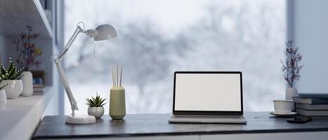 A laptop with a white desktop mockup and decor on a table in a modern home office workspace. photo