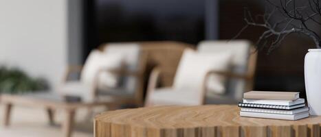 A close-up of a wooden table featuring books and a minimal ceramic vase photo