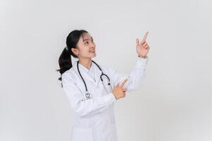 A doctor in uniform smiling and pointing at an empty space, as if she is recommending something. photo