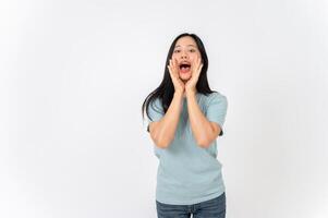 A beautiful Asian woman standing against a white studio background with a screaming, yelling pose. photo