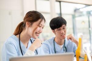 A female medical student is examining a model of bone joints and discussing it with her classmate. photo