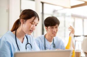 A female medical student is examining a model of bone joints and discussing it with her classmate. photo