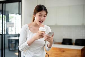 Excited woman reading texts on her smartphone with a surprised expression while standing in a cafe. photo