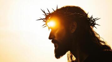 Silhouette of Jesus with a crown of thorns on his head, facing away from the camera photo