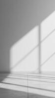 Bright sunlight filtering across white walled interior, casting long shadows on minimalist tiled flooring background photo