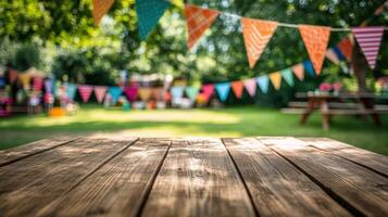 Empty wooden table top with a blurred background of colorful flags and a green tree photo