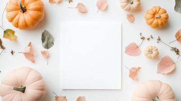 Minimal autumn flat lay composition mockup with blank invitation card, pastel light pink pumpkins and dry leaves on white background photo