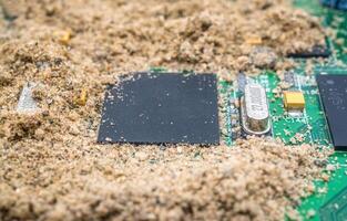 The computer chip was surrounded by sand photo