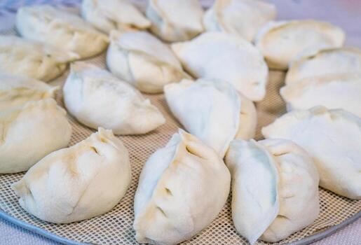 Raw Chinese dumplings on the plate ready for steaming photo