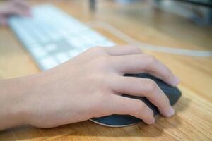 Girl's hand with computer mouse and keyboard photo