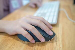 Girl's hand with computer mouse and keyboard photo