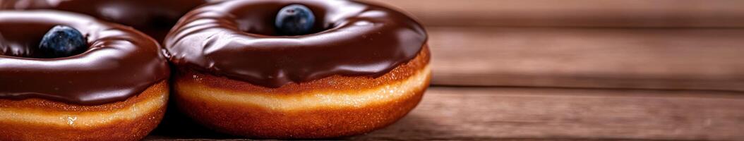 Delicious chocolate donuts topped with fresh blueberries on a rustic table photo